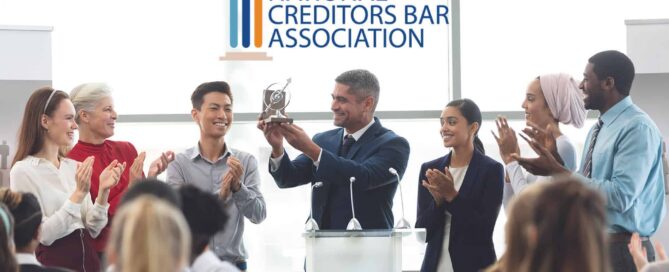 A group of professionals applauding for a recognition which they got from the national creditors bar association|A group of professionals applauding for a recognition which they got from the national creditors bar association|A group of professionals applauding for a recognition which they got from the national creditors bar association