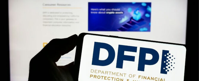 Person holding mobile phone with logo of Californian department DFPI on screen in front of web page